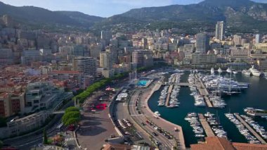 Monaco Marina 'ya kenetlenmiş teknelerin görüntüsü ve arka planda şehrin silüeti.