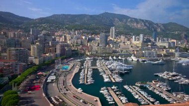 Monaco Marina 'ya kenetlenmiş teknelerin görüntüsü ve arka planda şehrin silüeti.