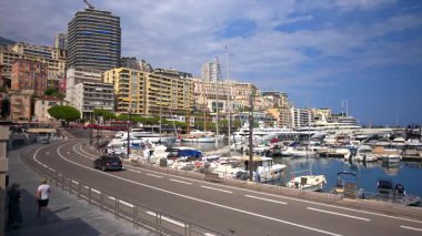 La Condamine, Monaco - 25 Ağustos 2024: Herkül Limanı yakınlarındaki bir sokakta hareket eden insanlar ve arabalar