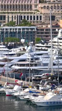 La Condamine, Monaco - 25 Ağustos 2024: Monaco Marina 'da arka planda şehrin ufuk çizgisi olan teknelerin görüntüsü. Dikey