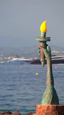 Theoule-sur-Mer, Fransa - 28 Ağustos 2024: Körfezin girişinde Calou 'nun Özgürlük Işığı heykeli görülüyor. Dikey
