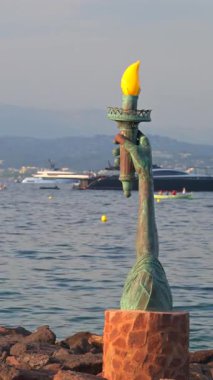 Theoule-sur-Mer, Fransa - 28 Ağustos 2024: Körfezin girişinde Calou 'nun Özgürlük Işığı heykeli görülüyor. Dikey