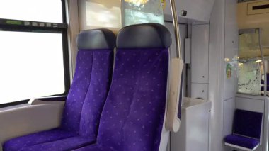 Vallauris, Fransa - 10 Ağustos 2024: Hareket halindeki bir trenin penceresinin yanındaki mor koltuklar