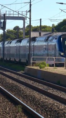 Antibes, Fransa - 6 Eylül 2024: İstasyonun yakınındaki raylarda hareket eden bir trene yaklaş. Dikey