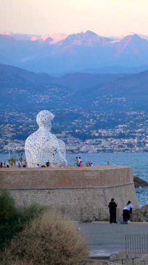 Antibes, Fransa - 6 Eylül 2024: Jaume Plensa 'nın Göçebe Şehir Heykeli' ne uzaktan bakış. Dikey