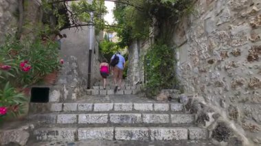 Saint Paul de Vence, Fransa - 19 Ağustos 2024: İnsanlar kentteki kaldırım taşı merdivenlerini tırmanıyor