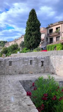 Saint Paul de Vence, Fransa - 19 Ağustos 2024: Gündüz vakti şehrin sokaklarındaki binaların görüntüsü. Dikey