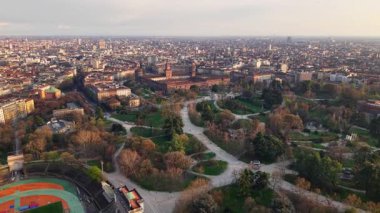İtalya, Milano 'daki Sforzesco Kalesi' nin hava aracı görüntüsü gün batımında binalarla çevrili.