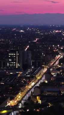 Akşamları İtalya, Milan 'da trafikte hareket eden arabaların insansız hava aracı görüntüsü. Dikey