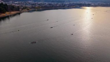 Aerial drone view of rowing boats moving on Lake Kawaguchiko near the Fujikawaguchiko town, Japan