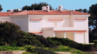 Fransa 'nın güneyinde, sahilde yeşilliklerle çevrili turuncu bir villa manzarası.