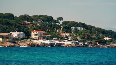 Sahildeki deniz dalgalarının kayalara çarptığı çok sayıda villanın uzak görüntüsü