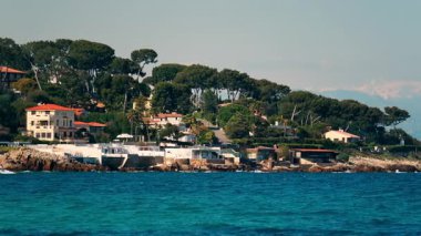 Sahildeki deniz dalgalarının kayalara çarptığı çok sayıda villanın uzak görüntüsü