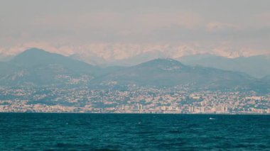 Arka planda dağlar olan Cap d 'Antibes yarımadasının uzak manzarası