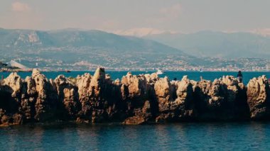 Fransa 'nın Antibes kentindeki deniz kıyısındaki birden fazla villanın uzak manzarası.