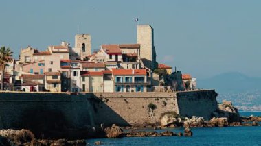 Distant view of people walking on the coast of Antibes, France
