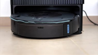 Yerde hareket eden ve dönen siyah bir robot elektrikli süpürgeyi kapat.