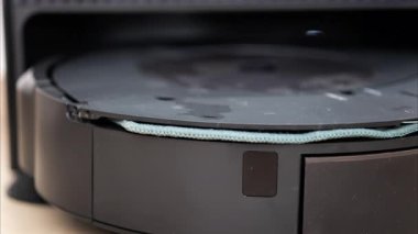 Yerde hareket eden ve dönen siyah bir robot elektrikli süpürgeyi kapat.