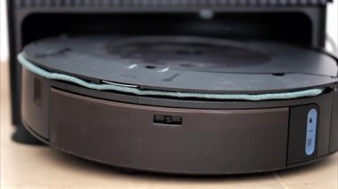 Yerde hareket eden ve dönen siyah bir robot elektrikli süpürgeyi kapat.