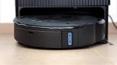 Yerde hareket eden ve dönen siyah bir robot elektrikli süpürgeyi kapat.