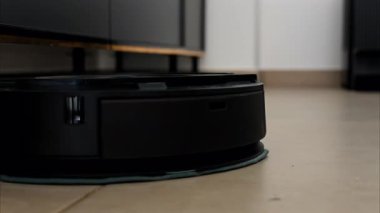 Yerde hareket eden ve dönen siyah bir robot elektrikli süpürgeyi kapat.
