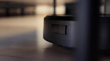 Yerde hareket eden ve dönen siyah bir robot elektrikli süpürgeyi kapat.