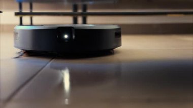 Yerde hareket eden ve dönen siyah bir robot elektrikli süpürgeyi kapat.