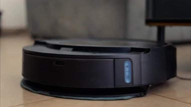Yerde hareket eden ve dönen siyah bir robot elektrikli süpürgeyi kapat.