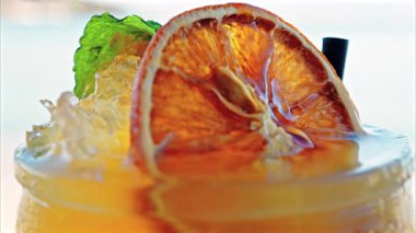 Arka planda bulanık deniz manzaralı bir masanın üzerindeki portakal kokteylini kapat.