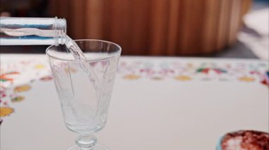 Close up of a glass of sparkling water on a white table and a blurred background
