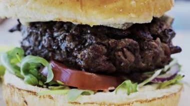 Bir restoranda tabakta bir hamburgeri yakın.