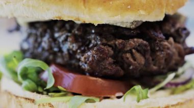 Bir restoranda tabakta bir hamburgeri yakın.