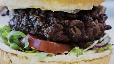 Bir restoranda tabakta bir hamburgeri yakın.