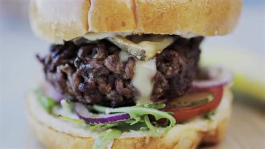 Bir restoranda tabakta bir hamburgeri yakın.