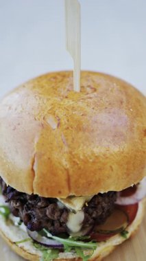 Bir restoranda tabakta bir hamburger yakın çekim. Dikey