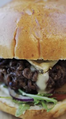 Bir restoranda tabakta bir hamburger yakın çekim. Dikey