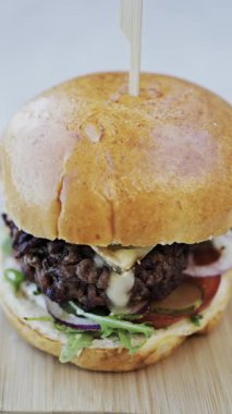 Bir restoranda tabakta bir hamburger yakın çekim. Dikey