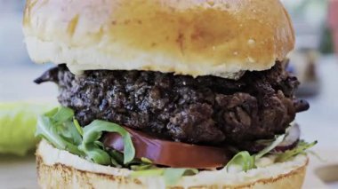 Bir restoranda tabakta bir hamburgeri yakın.