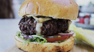 Bir restoranda tabakta bir hamburgeri yakın.