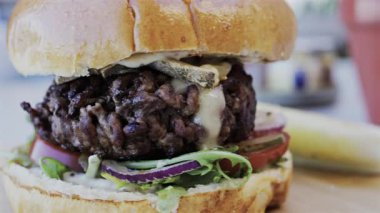 Bir restoranda tabakta bir hamburgeri yakın.