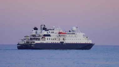 Güzel, Fransa - 28 Nisan 2025: Akşamları denizde hareket eden bir yolcu gemisinin uzak görüntüsü