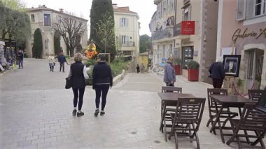Mougins, Fransa - 10 Nisan 2025: Bulutlu bir günde şehrin tuhaf sokaklarında boş teraslarda yürüyen insanları görmek