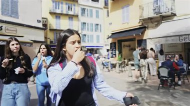 Antibes, Fransa - 27 Nisan 2025: Güneşli bir günde insanlar şehrin sokaklarında yürüyor