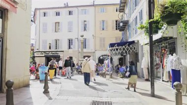 Antibes, Fransa - 27 Nisan 2025: Güneşli bir günde insanlar şehrin sokaklarında yürüyor