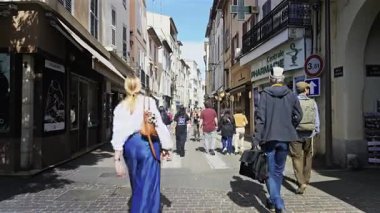 Antibes, Fransa - 27 Nisan 2025: Güneşli bir günde insanlar şehrin sokaklarında yürüyor