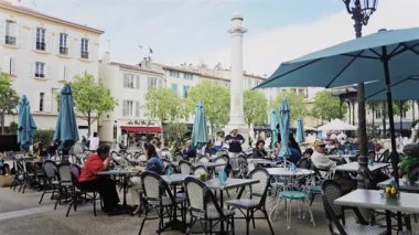 Antibes, Fransa - 27 Nisan 2025: İnsanlar sokakta terasta oturuyor