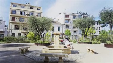 Antibes, Fransa - 27 Nisan 2025: Sokakta boş bir çeşmede oynayan iki kız