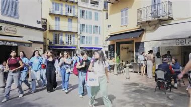 Antibes, Fransa - 27 Nisan 2025: Güneşli bir günde insanlar şehrin sokaklarında yürüyor