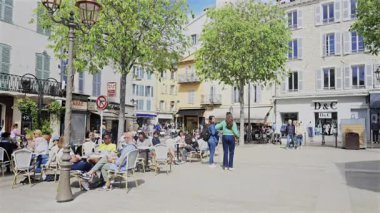 Antibes, Fransa - 27 Nisan 2025: Güneşli bir günde insanlar şehrin sokaklarında yürüyor