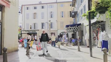Antibes, Fransa - 27 Nisan 2025: Güneşli bir günde insanlar şehrin sokaklarında yürüyor